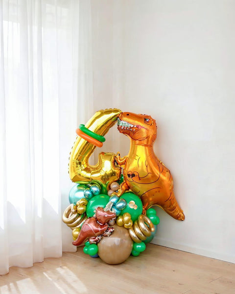 Bouquet escultural "Aventura Jurásica" con dinosaurio T-Rex naranja, número 4 dorado y globos verdes — Perú Balloons, Lima