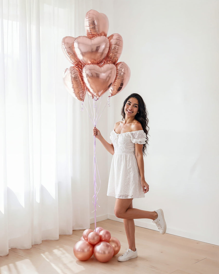 Bouquet de globos flotantes con helio en tonos rosa dorado sobre fondo neutro