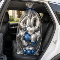 Bouquet de globos 40 plateados y azules, envuelto en celofán en el asiento trasero de un auto