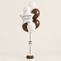 Bouquet de globos blancos y chocolate con estrella personalizada y base de globitos, sobre fondo beige.