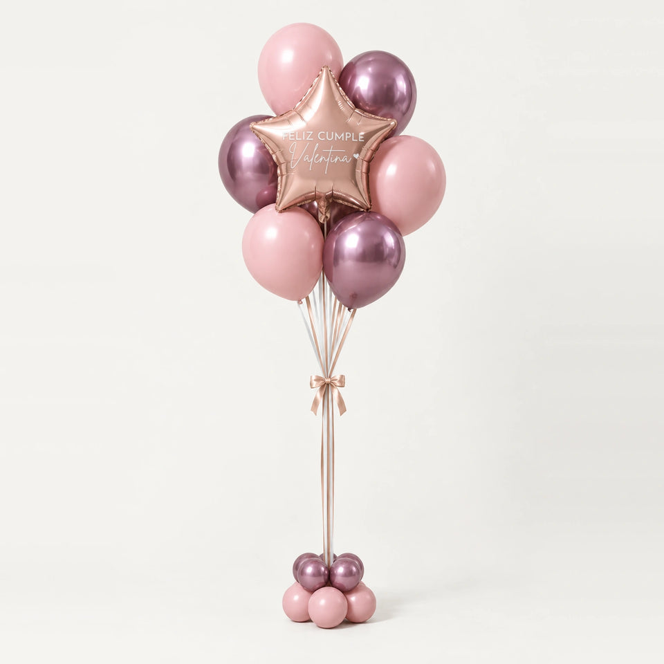 Bouquet de globos rosas con estrella oro rosa y base de globitos, sobre fondo claro.