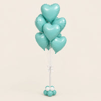 Ramo de globos de corazón aqua con lazo blanco y base de globitos, sobre fondo claro