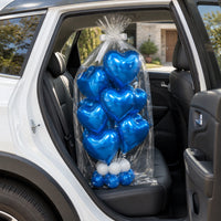 Ramo de globos de corazón azul empacado en celofán, sobre el asiento trasero de un auto.