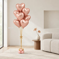 Ramo de globos de corazón oro rosa en una sala, con medidas indicadas de 200 cm de alto y 70 cm de ancho