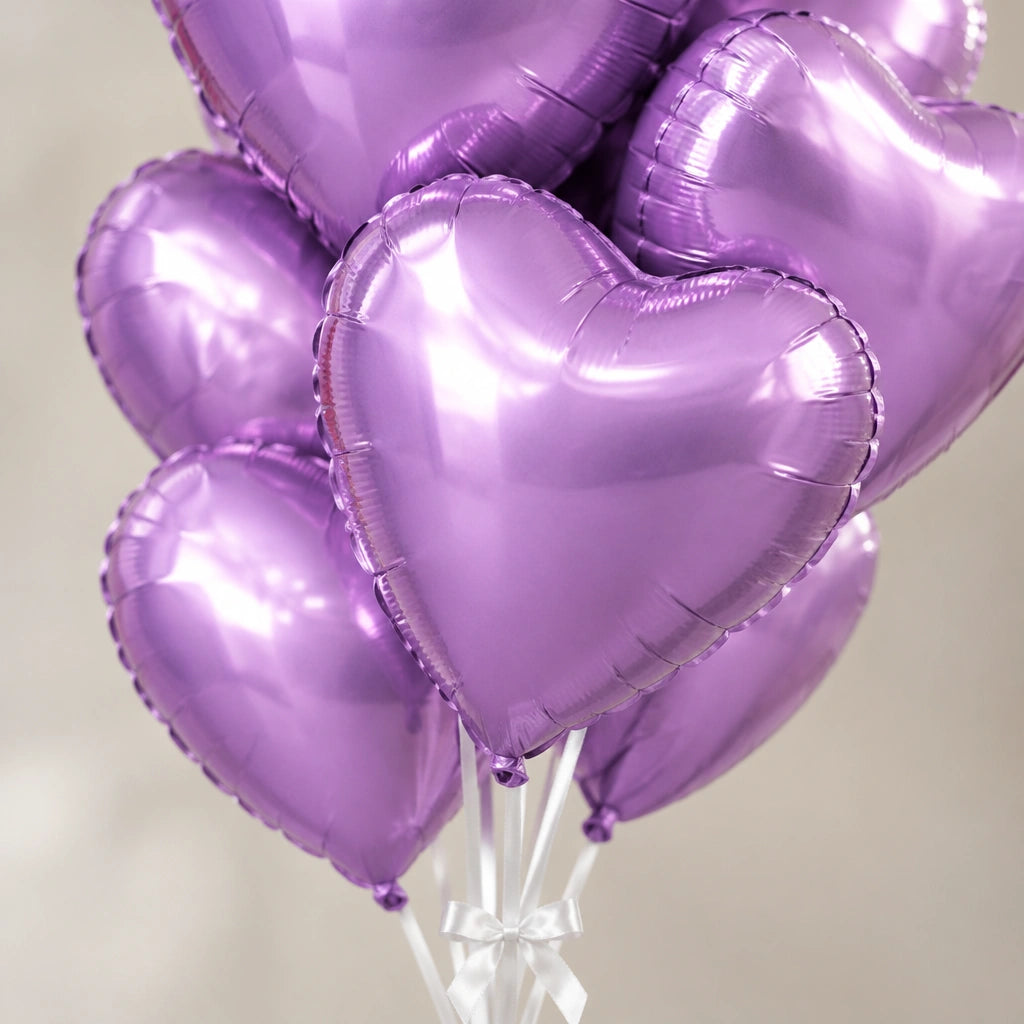 Ramo de globos de corazón lila metalizado, detalle de los corazones y las cintas blancas.