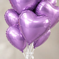 Ramo de globos de corazón lila metalizado, detalle de los corazones y las cintas blancas.