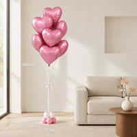 Ramo de globos de corazón rosados junto a un sofá, con medidas indicadas de 200 cm de alto y 70 cm de ancho.